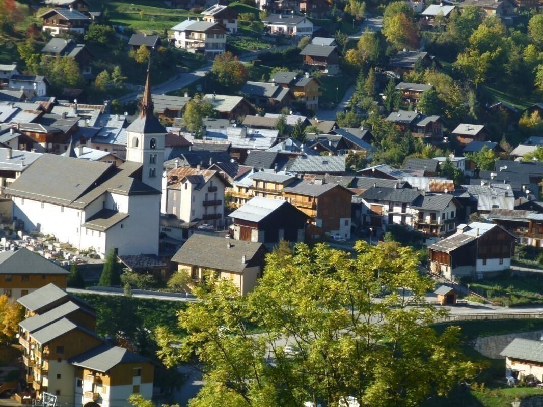 A residential area with houses, a church, and a bridge.