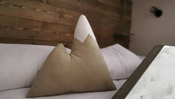 A bed with a wooden headboard, a white pillow, and a brown pillow.