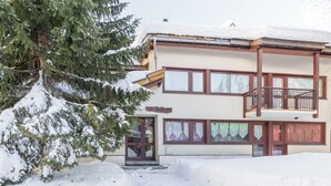 A two-story building with a balcony and a snow-covered roof.