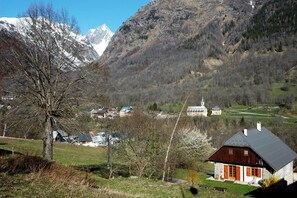 En bjerglandsby med traditionelle huse, en kirke og en sø.