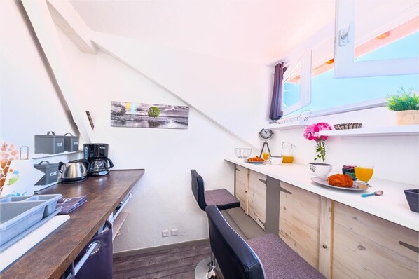A compact kitchen with a dining area, equipped with a coffee maker, kettle, and a small dining table. - LA TARINE N°3 - PALLUD (PALLUD)