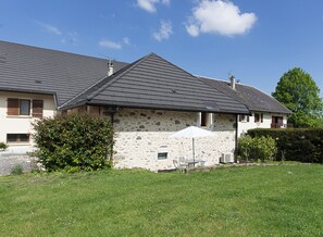 A stone house with a grey roof, a small garden, and a white umbrella. - LE GRENIER A BLE - ENTRELACS (ENTRELACS)