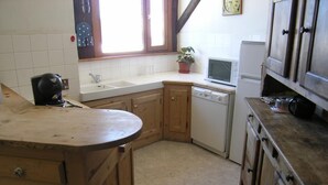 A kitchen with wooden cabinets, a dishwasher, a microwave, and a sink.