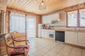 A wooden interior with a kitchen area, including a refrigerator, oven, and dishwasher. - L'AIGLE - BONNEVAL SUR ARC (BONNEVAL SUR ARC)