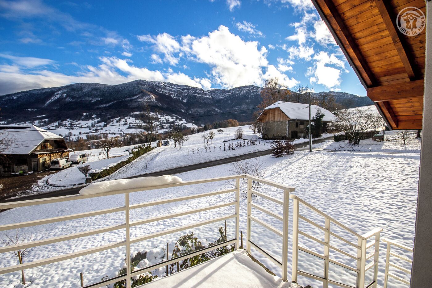 A snowy mountain landscape with a wooden building and a snow-covered road.