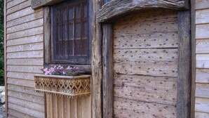 A rustic wooden building with a window and a wooden door. - LE RIEU - CHAMPAGNEUX (CHAMPAGNEUX)