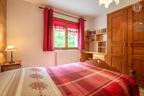 Une chambre confortable avec un lit, une table de chevet, une bibliothèque et une armoire.