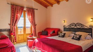 Una camera da letto con un letto grande, un divano rosso e un soffitto in legno.