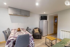 A compact living space with a dining area, a kitchenette, and a small seating area. - THE ATTIC - HAUTELUCE LES SAISIES (HAUTELUCE LES SAISIES)