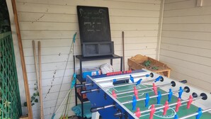 Une table de baby-foot avec un tableau noir en arrière-plan.