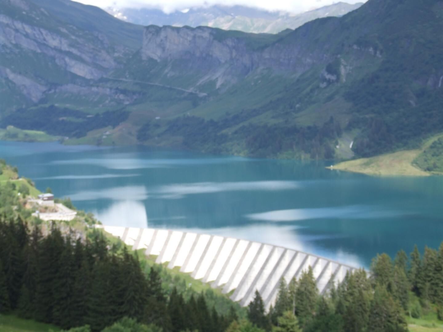 A mountainous landscape with a large reservoir and a dam.