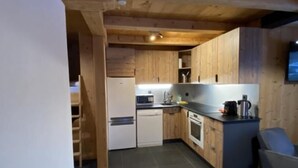 Eine moderne Küche mit Holzausstattung, einem Esstisch und einem Einbauofen.