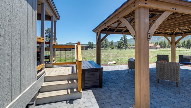 A covered outdoor area with a wooden pergola, a wooden bench, and a fire pit. - 3 Mi to Grand Canyon Railway: Williams Retreat (Williams)
