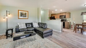 A modern living room with a sectional sofa, a coffee table with chess pieces, and a framed picture on the wall. - 3 Mi to Grand Canyon Railway: Williams Retreat (Williams)