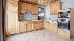 Una cocina con armarios de madera, un microondas y un horno.