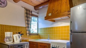 A kitchen with wooden cabinets, a stainless steel dishwasher, a stove, and a refrigerator.