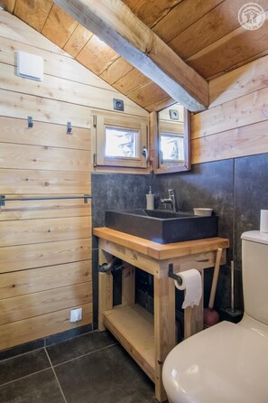 A wooden-paneled bathroom with a sink, toilet, and two small windows. - LA TORNA - BONNEVAL SUR ARC (BONNEVAL SUR ARC)
