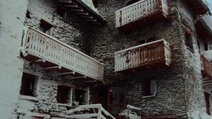 Um edifício de pedra com varandas cobertas de neve.