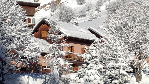 A snow-covered mountain village with wooden cabins and trees. - CHALET L'ANDORSE - VALLOIRE (VALLOIRE)