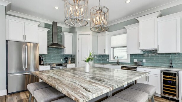 A modern kitchen with a large island, stainless steel appliances, and a green-tiled backsplash. - Calla Lily Cove : Breathtaking Home w/Elevator In a Gated Community-Sleeps 12 (Navarre)