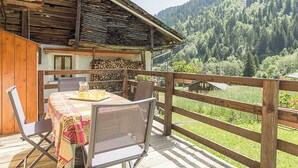 Une cabane en bois dotée d’un balcon donnant sur une vallée boisée.
