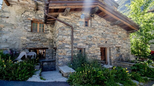 Ein Steinhaus mit Holzbalken und rustikalem Äußeren.
