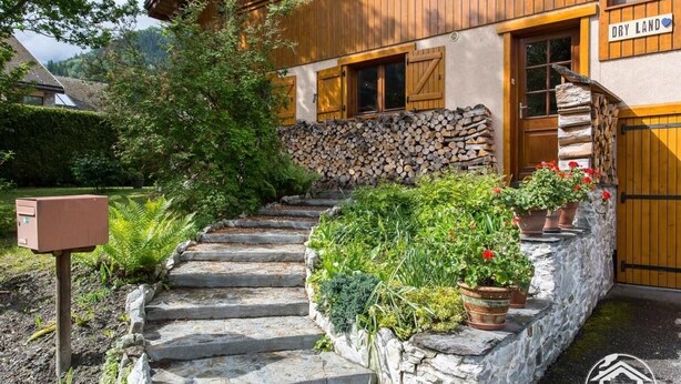 A rustic wooden building with a stone staircase leading to a wooden door marked "DRY LAND."
