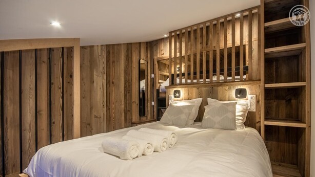 A bedroom with a wooden headboard, a bed with white linens, and a built-in wardrobe with shelves. - ROND-POINT DES PISTES - INTERLUDE (TIGNES)