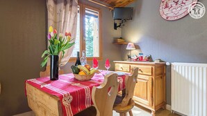 A cozy dining area with a wooden table and chairs, a fruit basket, and a vase of flowers. - LE BOUQUETIN - VAL CENIS (VAL CENIS)