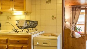 A kitchen with wooden cabinets, a dishwasher, and a tiled backsplash. - LE BOUQUETIN - VAL CENIS (VAL CENIS)