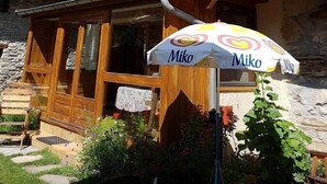 A wooden chalet with a balcony adorned with colorful flowers, a yellow umbrella, and a sign for 'Miko'. - LE BOUQUETIN - VAL CENIS (VAL CENIS)