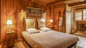 A wooden cabin bedroom with a bed, two bedside lamps, a painting on the wall, and a window. - LA FERME D'EUGENIE - FLUMET (FLUMET)