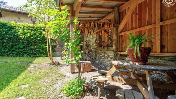 Ein rustikales Holzhaus mit einer Steinwand und einem Holztisch mit Bänken.