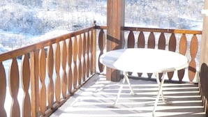 A wooden balcony with a white table and chairs, overlooking a snowy landscape. - LES RUFFES - LES BELLEVILLE (LES BELLEVILLE)