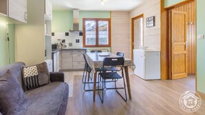 A compact living space with a kitchenette, dining area, and a small refrigerator. - LES RUFFES - LES BELLEVILLE (LES BELLEVILLE)