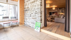 Un interior acogedor con pared de piedra, muebles de madera y vistas al exterior.
