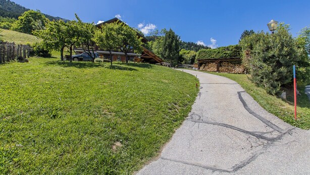 A rural pathway leading to a house with a sloped roof, surrounded by green grass and trees. - LA BERTINA - MERIBEL LES ALLUES (MERIBEL LES ALLUES)
