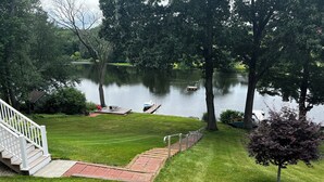 A well-maintained lawn with a wooden deck leading to a dock by a calm lake. - Stunning Lakefront Escape! Book Your Dream Getaway! (Woodstock)