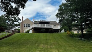 A two-story house with a covered front porch and a staircase leading to the entrance. - Stunning Lakefront Escape! Book Your Dream Getaway! (Woodstock)