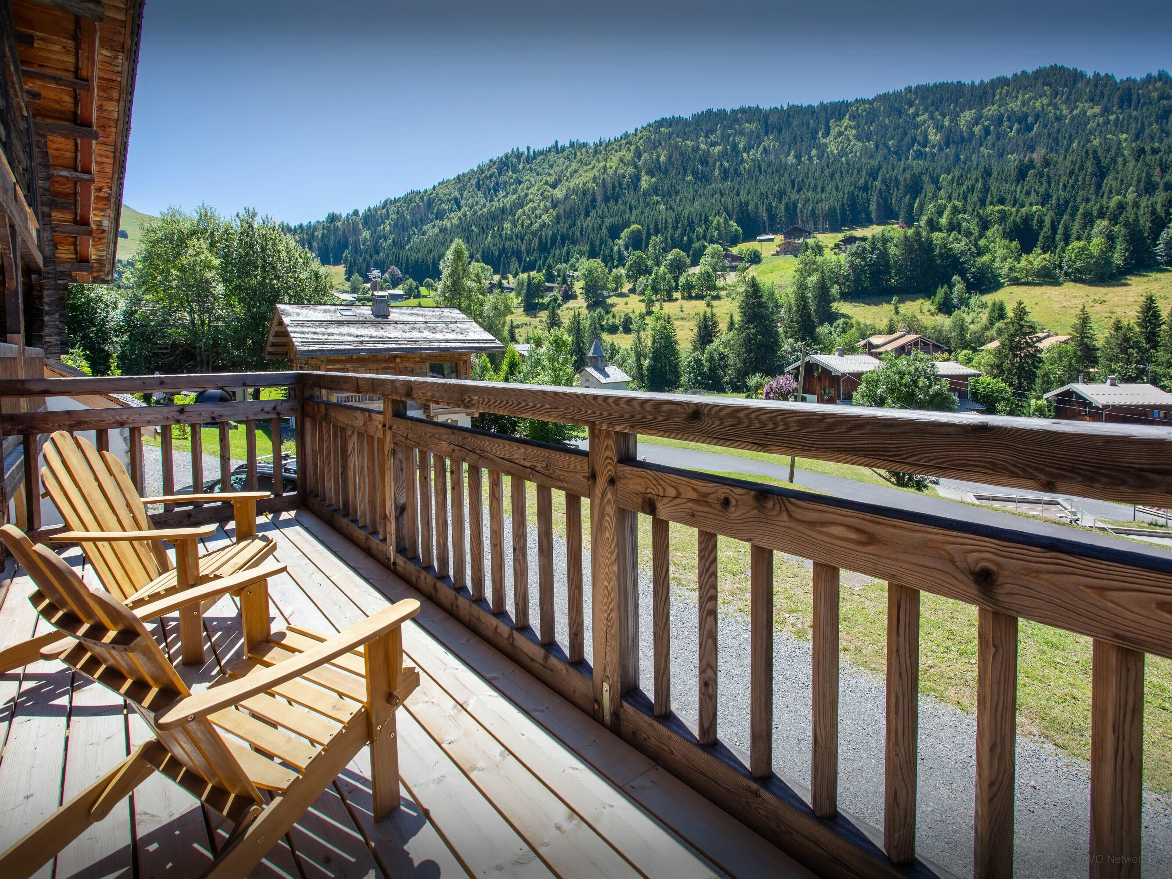 Una terraza de madera con vistas a un paisaje montañoso.