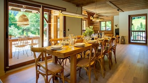 Ein Essbereich aus Holz mit einem großen Tisch, gedeckt für sechs Personen, umgeben von Holzstühlen.