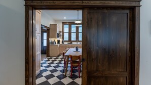 Una cocina con piso de cuadros, armarios de madera y una mesa de comedor con sillas.