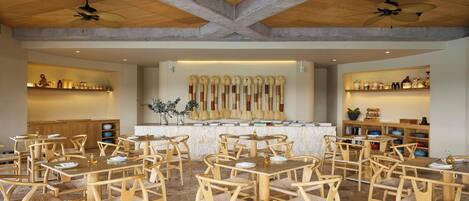 Un restaurant doté de mobilier en bois et d’un bar central.