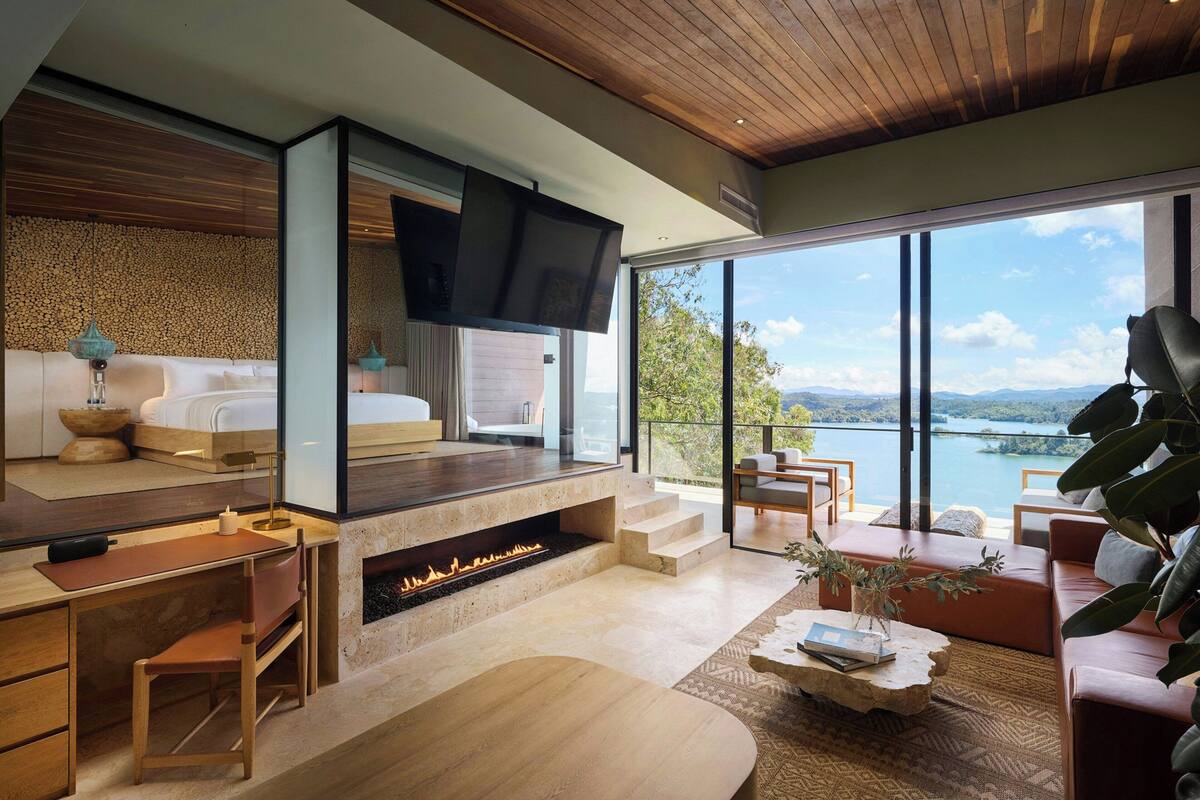 Una sala de estar moderna con chimenea, un sofá, una mesa de centro y un televisor.