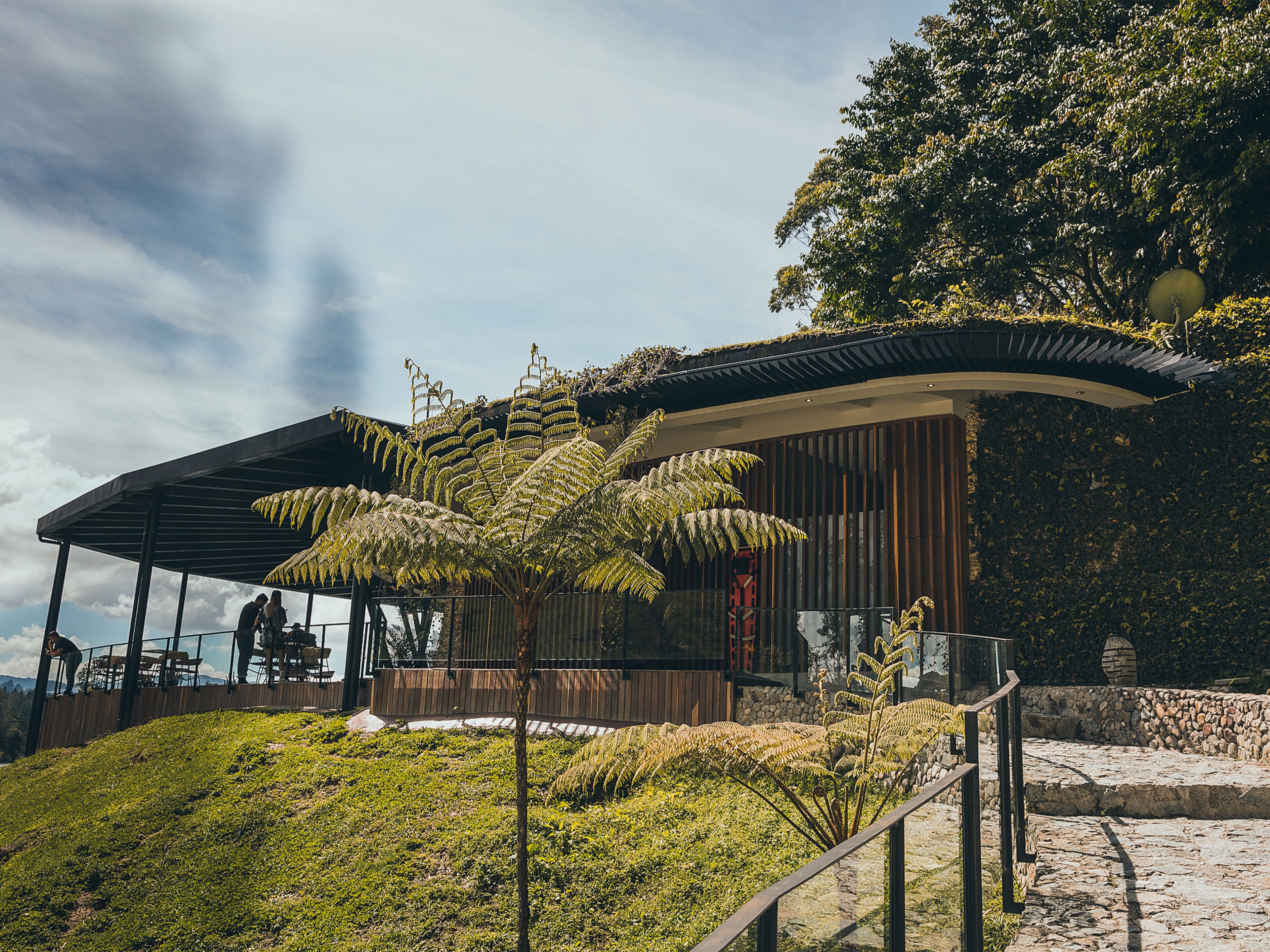 A modern building with a covered seating area and a view of the surrounding landscape.