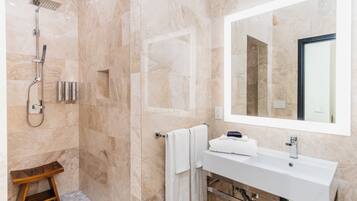 A modern bathroom with a shower, a sink, and a mirror.