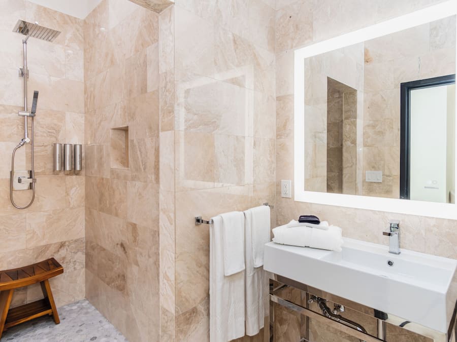 A modern bathroom with a shower, a sink, and a mirror.