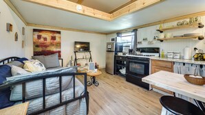 Una cocina acogedora con vigas de madera, un comedor y una sala de estar con cama.