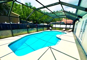 A swimming pool with a metal roof and a fenced area.
