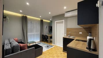 Appartement Deluxe | Coin séjour | Télévision LED de 80 cm avec chaînes par câble, chauffage par le sol